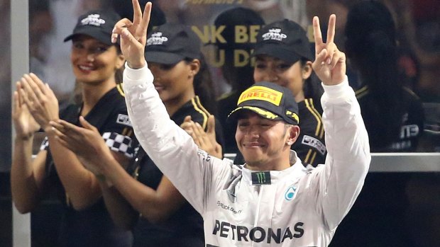 Mercedes-AMG's British driver Lewis Hamilton celebrates near the podium at the Yas Marina circuit in Abu Dhabi this morning.