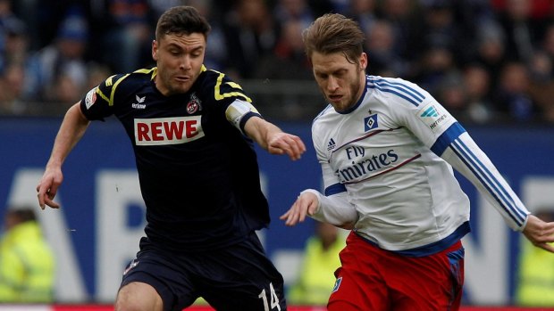 Cologne's Jonas Hector, left, and Hamburg's Aaron Hunt challenge for the ball.