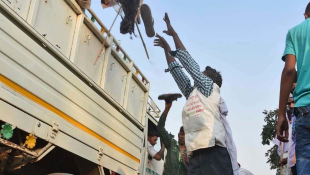 A man loads a truck with footwear of victims of a stampede on a crowded bridge on the outskirts of Varanasi, India.