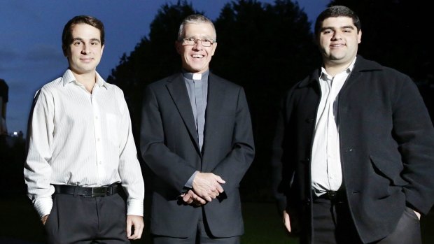  Father Ray Meagher, centre, stands with young trainee priests James Arblaster and Ronnie Maree in the grounds of the Seminary of Good Shepard at Homebush.