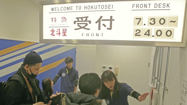 Visitors stops at the front desk at Train Hostel Hokutosei in Tokyo. 
