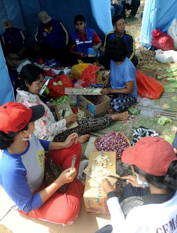 People prepare food at Klungkung sport centre.