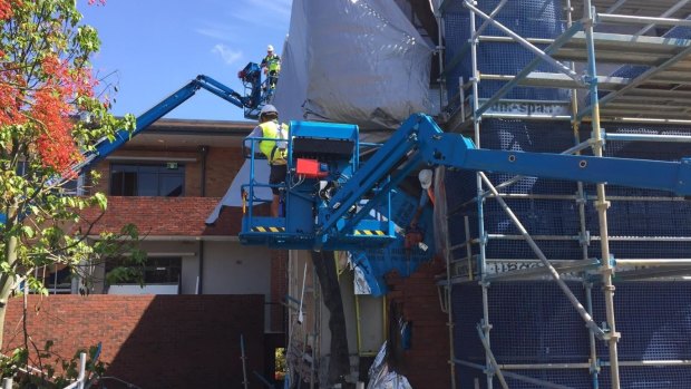 Scaffolding and tarpaulins cover the damaged front of Villanova College's Veritas Building where a brick wall has collapsed.