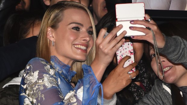 Margot Robbie takes a selfie with fans at the premiere in Toronto.