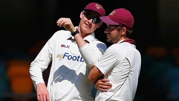 Matthew Renshaw and Joe Burns in the field during day four of the Sheffield Shield match between Queensland and South Australia at the Gabba.