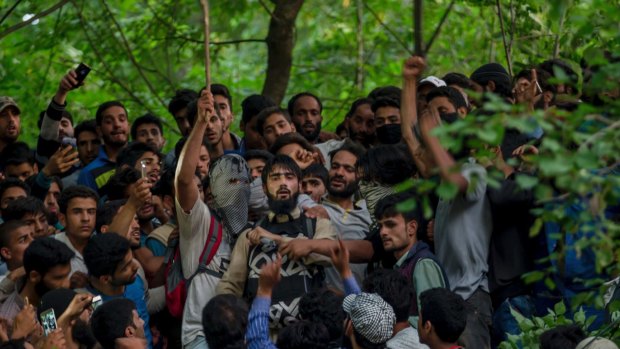 Kashmiri villagers surround the rebel as he pays tribute to Sabzar Ahmed Bhat.