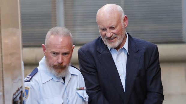 Former NSW Minister Ian Macdonald is escorted to a prison truck after his sentencing hearing on Friday.