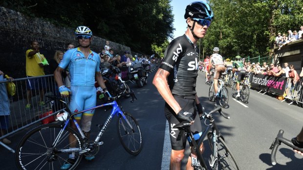 Chris Froome waits for a spare wheel after a crash in the last kilometres of the sixth stage.