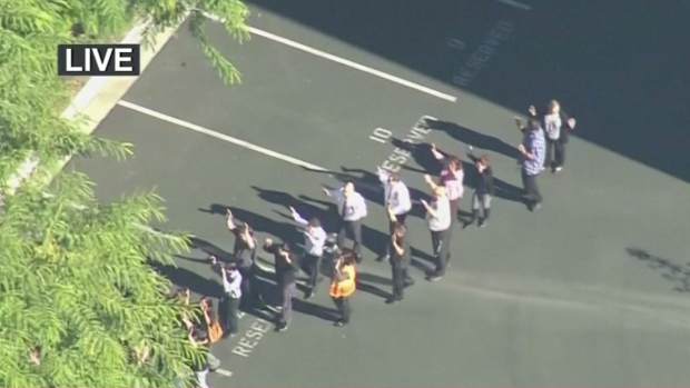 Workers are evacuated from the Inland Regional Centre in San Bernardino after a shooting.