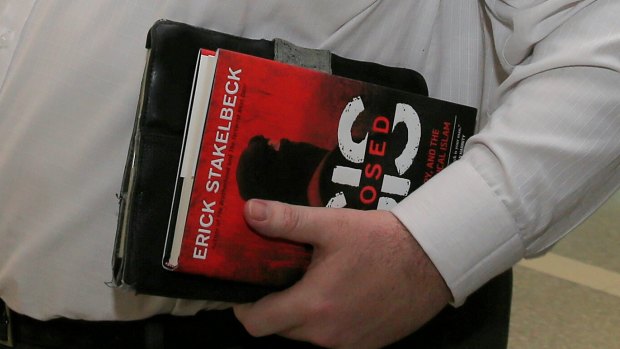 Coalition MP George Christensen, a keen purchaser of books on Islamic State, arrives at Canberra airport earlier this year carrying the book 'ISIS Exposed' by Erick Stakelbeck.