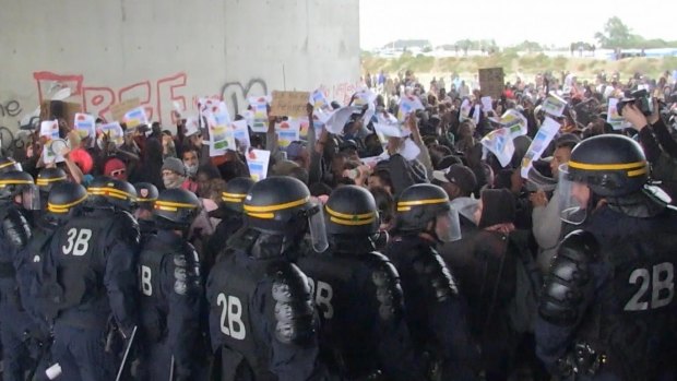 Police control protesters, during a demonstration near the migrant camp, in Calais, France.