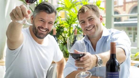 Former Wallabies Adam Ashley Cooper (left) and Drew Mitchell with their Backline Wines shiraz.