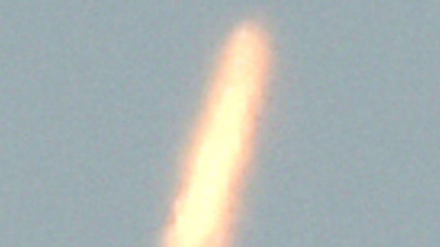 An unidentified object - thought to be North Korea's rocket launch - is photographed from Dandong, China, on Sunday.