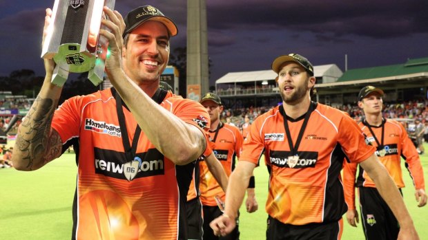 Reigning champs: Mitchell Johnson of the Scorchers carries the trophy after winning last season's BBL T20 final against the Sydney Sixers in January.