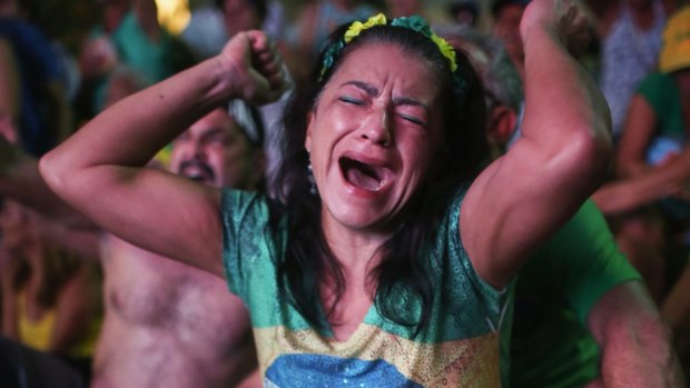 A pro-impeachment supporter dressed in Brazilian national colours cheers as a 'Yes' vote is cast in the lower house. 