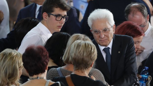Italian President Sergio Mattarella, right, greets relatives of some of the earthquake victims at the mass funeral.