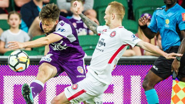 Chris Harold of Perth Glory and Jack Clisby contest possession.