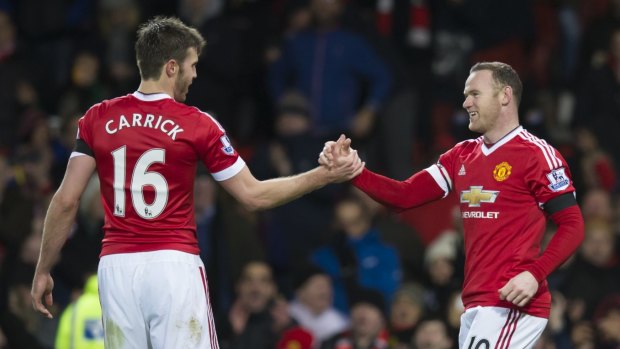 Manchester United's Wayne Rooney, right, shakes hands with teammate Michael Carrick.