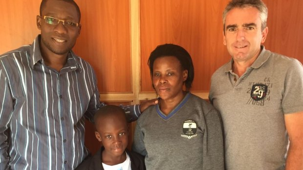 Benson with his mother and Kyampisi Childcare director Peter Michael (left) and Rodney Callanan (right)