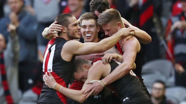Zach Merrett and David Zaharakis, two of the Bombers' best, celebrate their win with teammates.