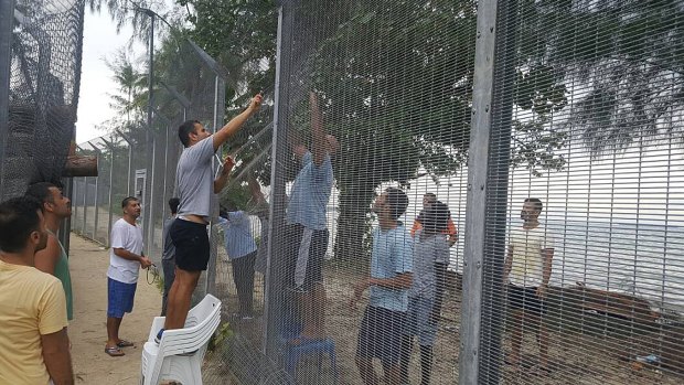 Refugees securing a recently damaged perimeter fence at the Manus Island immigration detention centre on October 30.