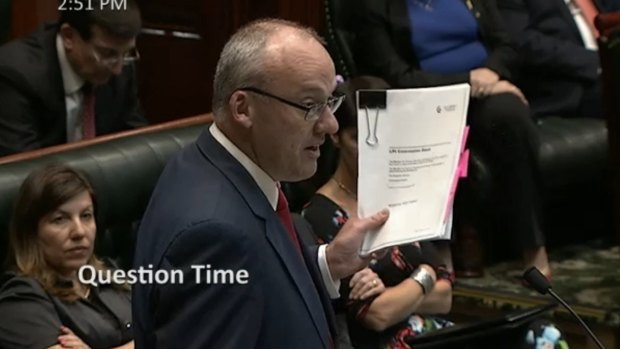 Opposition leader Luke Foley lifts a leaked copy of the land titles registry privatisation contract during Question Time on Thursday.