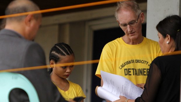 Alleged paedophile Peter Gerard Scully, 52, and his former live-in partner Carmen Ann Alvarez (left, both in yellow shirts) are arraigned in Cagayan de Oro on Tuesday. 