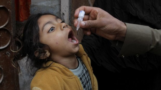 A Pakistani health worker gives a polio vaccine to a child in Peshawar, Pakistan, which is one of the last two countries where polio currently remains endemic.