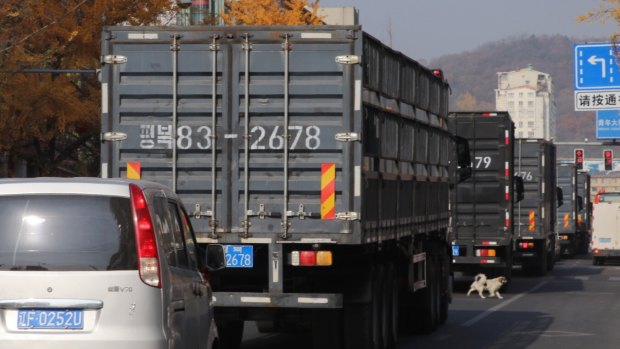 North Korean trucks heading to a local logistics centre lined up on a street in Dandong, China.