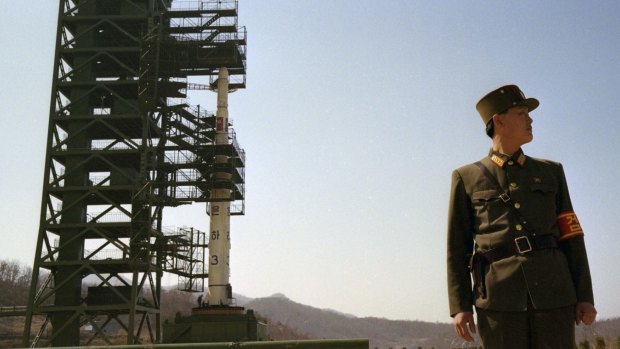 In this April 8, 2012 photo, a North Korean soldier stands guard in front of the country's Unha-3 rocket at Sohae Satellite Station in Tongchang-ri, North Korea. 
