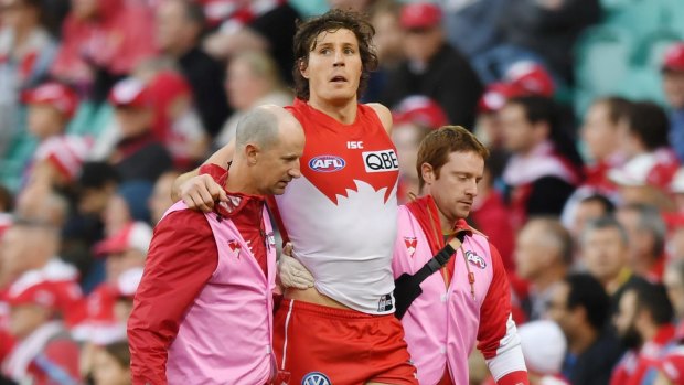 Scare: Kurt Tippett is helped off the pitch after re-injuring his ankle against Carlton at the SCG.