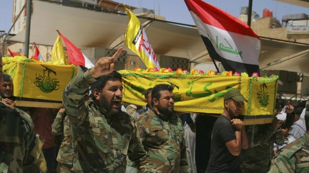 Members of a Shiite militia carry the coffins of their comrades killed fighting outside Fallujah for burial in the Shiite holy city of Najaf. The militias have raised fears of sectarian revenge in Fallujah, a mainly Sunni city.