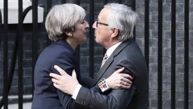 Theresa May greets Jean-Claude Juncker, president of the European Commission.