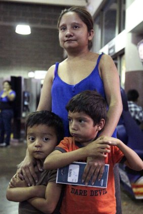 Floridalma Bineda Portillo, of Guatemala, and her sons wait at a bus terminal in Phoenix, Arizona. They were among 400 women and children caught crossing from Mexico into south Texas last month. After being flown to Arizona when border officials ran out of space to house them, they were dropped at bus stations. 