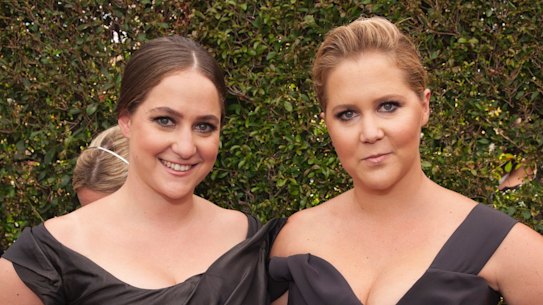 Schumer and sister Kim Caramele matched in similar Vivienne Westwood black gowns and hairstyles, which is probably another joke on us.