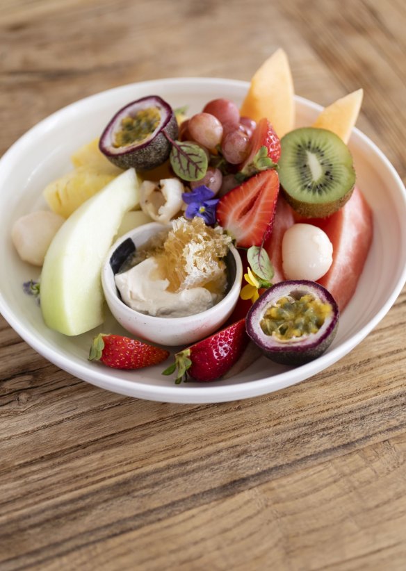 Fresh fruit platter with yoghurt and honeycomb.
