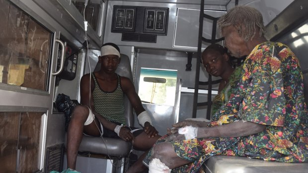 Victims of a suicide bomb attack at a refugee camp receive treatment in an ambulance, in Maiduguri.
