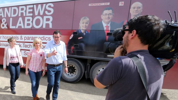 Then-opposition leader Daniel Andrews in front of the Labor campaign bus last year, which featured a picture of firefighter Peter Bevis. 
