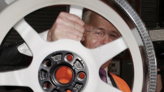 Mr Turnbull lifts a 7.3kg carbon fibre wheel at Carbon Revolution.