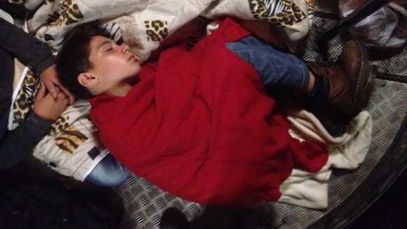 A migrant boy sleeps on the floor of a bus provided to refugees leaving Hungary on Saturday.