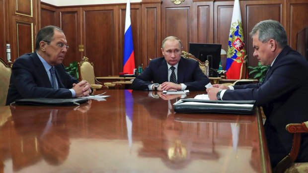 Russian President Vladimir Putin, centre, and Foreign Minister Sergey Lavrov, left, listen to Defence Minister Sergei Shoigu in Moscow, Russia on Thursday.