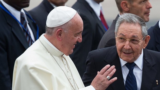 Pope Francis walks with Cuban President Raul Castro as the pontiff arrives in Havana for a three-day visit.
