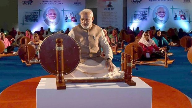 The photo shows Prime Minister Narendra Modi at a spinning wheel in a pose similar to Ghandi's.