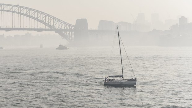 A lone sailboat tries to navigate through the smoke.
