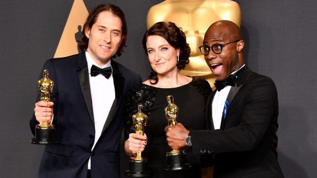 From left: <i>Moonlight</i> producers Jeremy Kleiner and Adele Romanski pose with director Barry Jenkins in the press room.