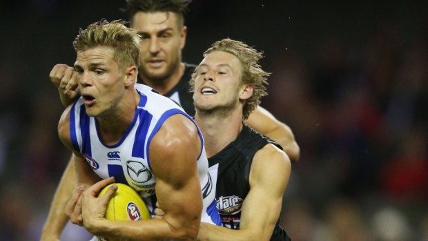 Mason Wood of the Kangaroos marks the ball against Jimmy Webster of the Saints.