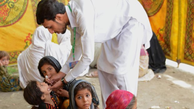 A Pakistani health worker in Bannu giving  the polio vaccine to children last year.