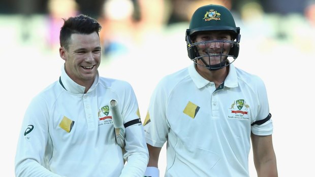 All smiles: Peter Handscomb, left, and Renshaw walk off the Adelaide Oval after claiming victory.