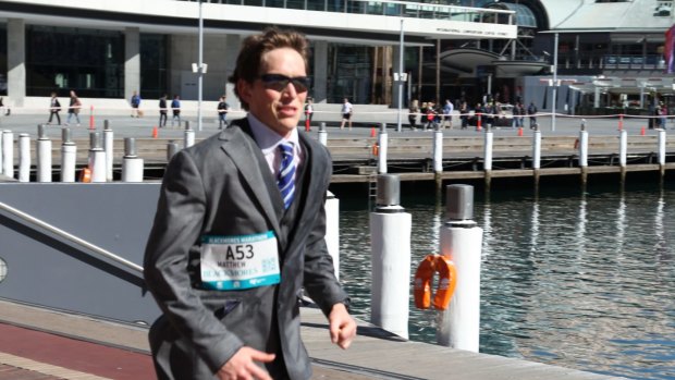 Sydney lawyer Matthew Whitaker, 25, ran the 42-kilometre Sydney Running Festival dressed in a suit – and broke a Guinness World Record.