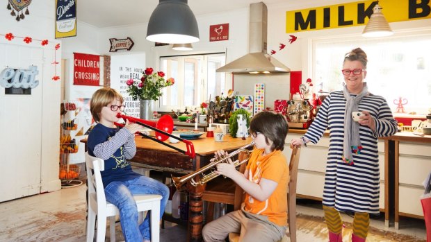 The front door opens to a large kitchen and dining room. “I love that visitors are greeted with this communal space”, says Ruth, pictured with Archie (on trombone) and Gus (on trumpet).